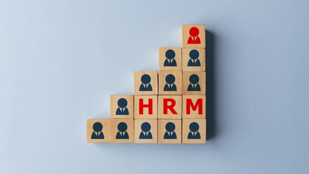 HRM - Human resource management and recruitment concept on wooden cubes.